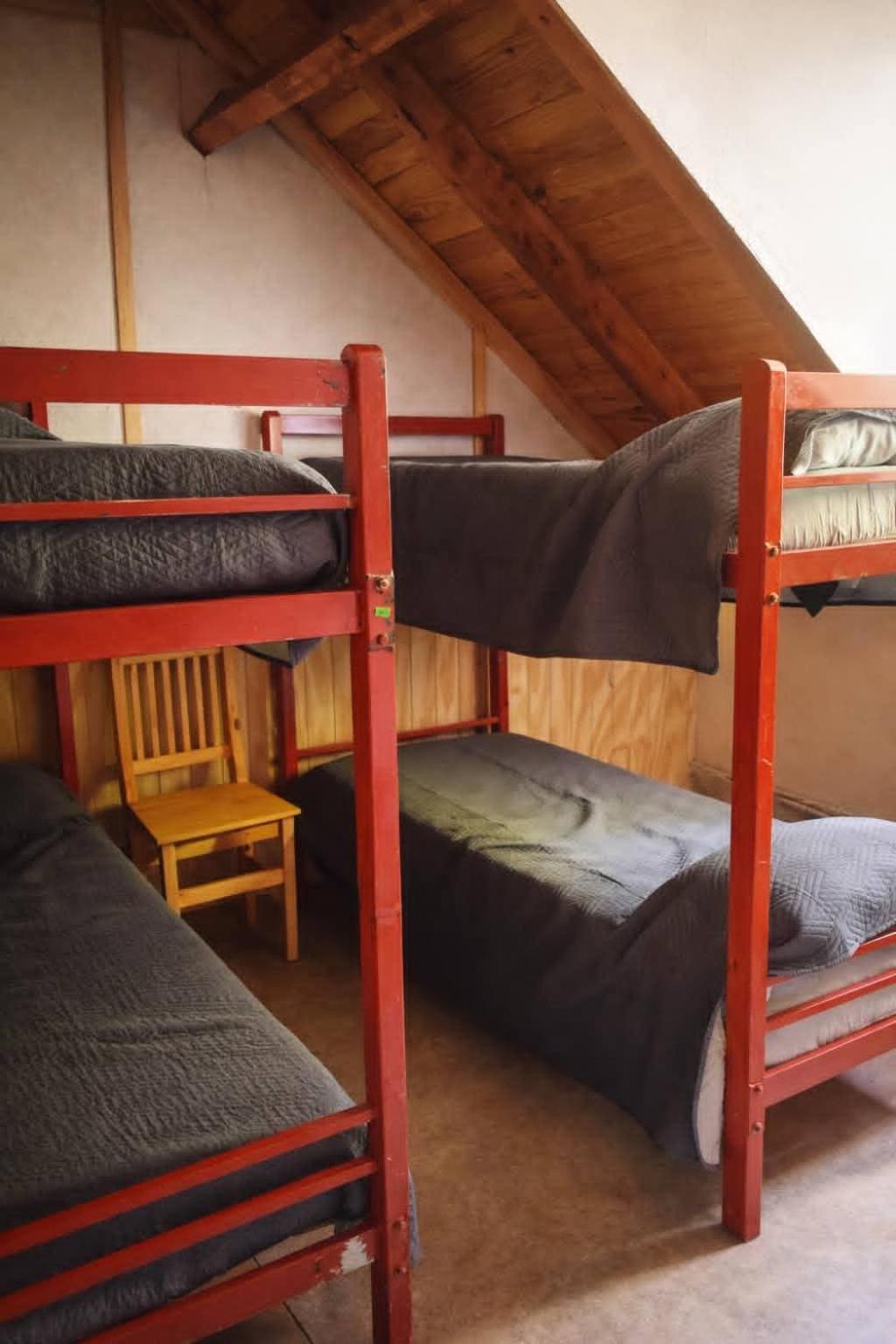 Dos cuchetas en una habitación con techo inclinado